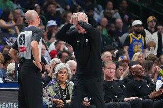 Moses Moody of the Warriors is carted off after apparent knee injury late in OT against Mavs image